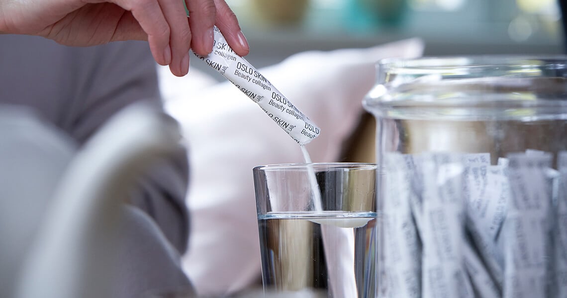 Kobieta wyciągająca saszetkę ze szklanej szklanki